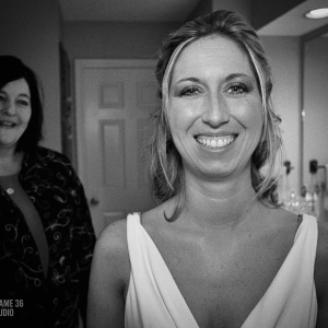 Bride smiling warmly in a candid moment before the ceremony, indoor wedding preparation scene